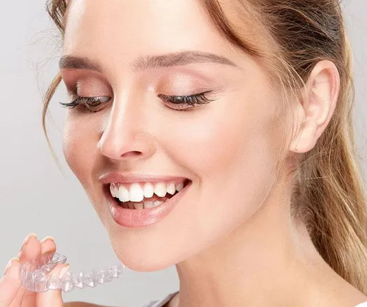 Invisalign patient admiring new clean clear trays